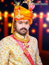 Elegant wedding groom sherwani with intricate gold embroidery and vibrant orange turban from Modern Marwar